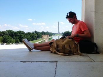 Man relaxing against view of washington monument