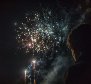 Firework display against sky at night