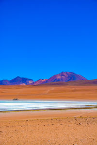 Scenic view of mountains against clear blue sky