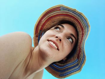 Close-up portrait of smiling young woman against sky