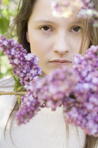 Close-up portrait of woman with purple flower