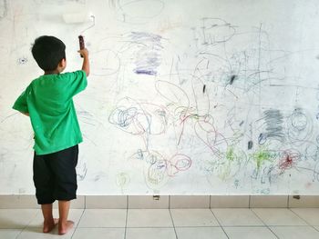 Rear view of man standing against wall