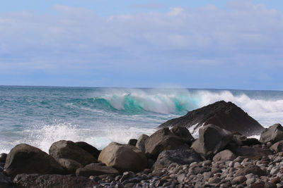 Scenic view of rocks in sea against sky
