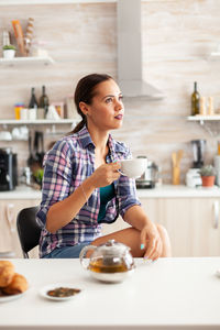 Portrait of young woman sitting on table