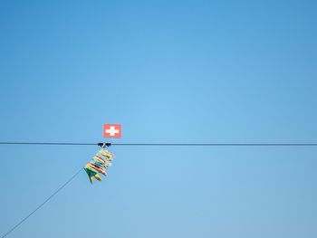 Low angle view of hanging against clear blue sky