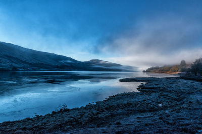 Scenic view of lake against sky during winter