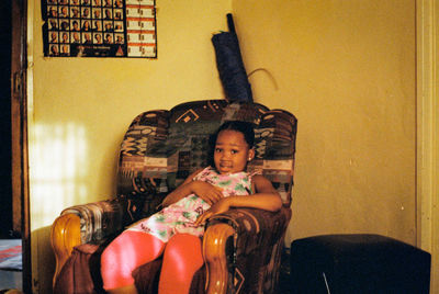 High angle view of girl sitting on sofa at home