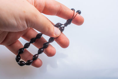 Close-up of hand holding eyeglasses against white background