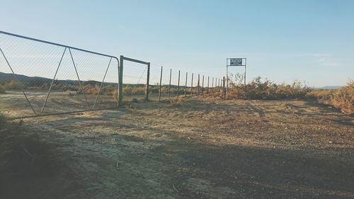 Fence on field against clear sky