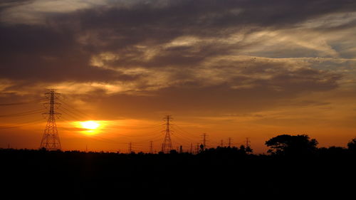 Silhouette electricity pylon against sky during sunset