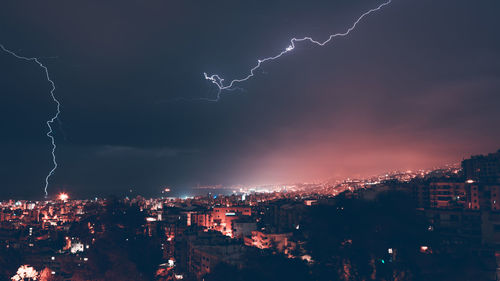 High angle view of illuminated cityscape against sky at night