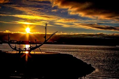 Silhouette boat in sea against sky during sunset