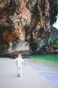 Rear view of woman standing at beach