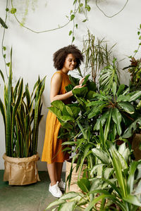 Young woman standing by potted plant