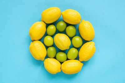 High angle view of lemons in container against blue background