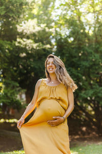 Portrait of a smiling young woman against trees