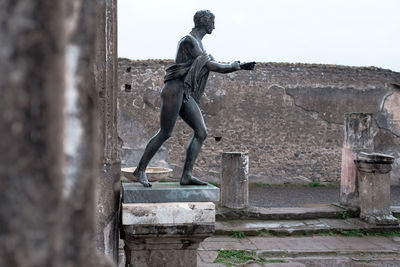 Statue of woman against wall