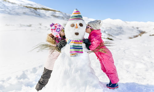 Spain, asturias, kids playing with snowmen, kissing