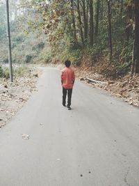 Rear view of girl walking on road