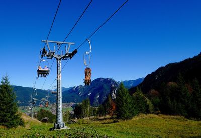 Overhead cable car in mountains against clear blue sky