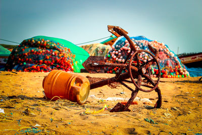 Close-up of abandoned bottle on beach against sky