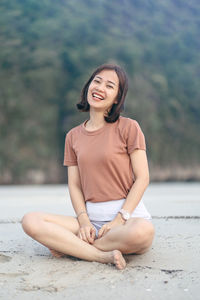 Portrait of smiling young woman sitting outdoors