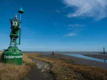 Road by sea against blue sky