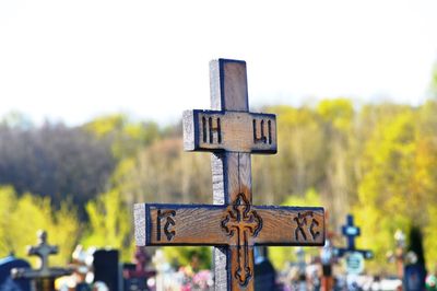 Close-up of cross on wood against clear sky