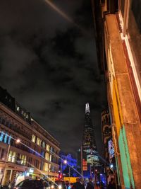 Low angle view of illuminated buildings against sky at night