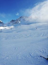 Scenic view of snowcapped mountains against blue sky