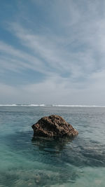 Rock formation in sea against sky