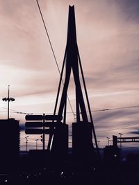 Silhouette erasmus bridge against sky during sunset in city