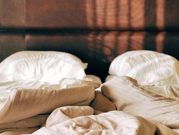 Low section of white relaxing on bed at home