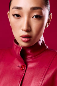Close-up of young woman against yellow background