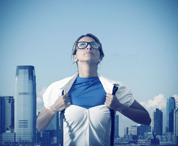 Full length of man standing by modern buildings against sky