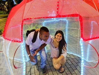 Portrait of smiling young woman with pink umbrella