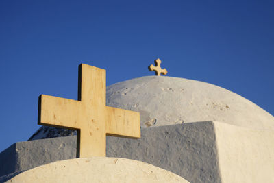 Low angle view of cross against clear blue sky