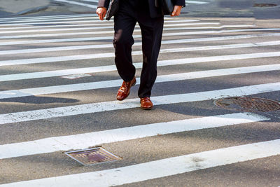 Low section of man crossing road