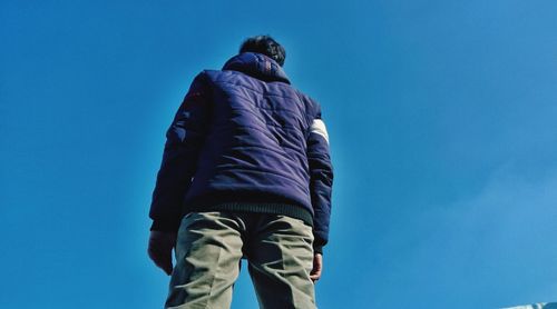 Low angle view of man against blue sky