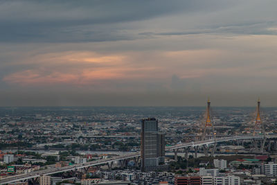 Aerial view of buildings against cloudy sky during sunset