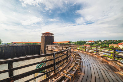 Boardwalk amidst buildings in city against sky