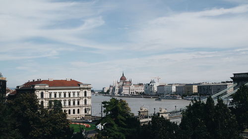 Buildings in city against cloudy sky