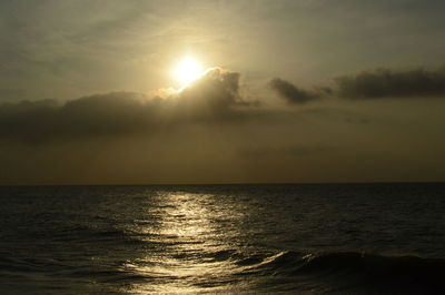 Sunlight streaming through sea against sky during sunset