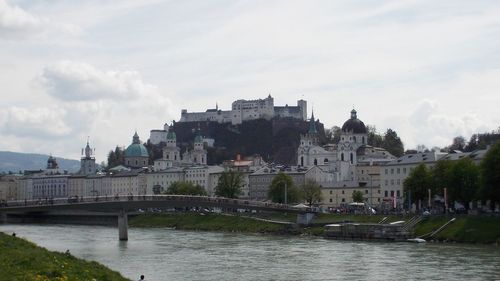 Bridge over river against buildings in city