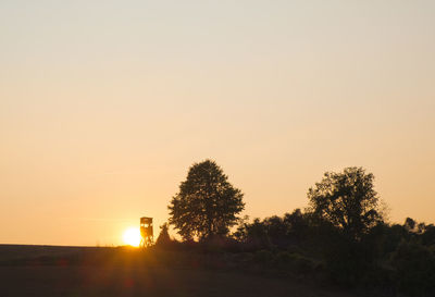 Silhouette trees against clear sky during sunset