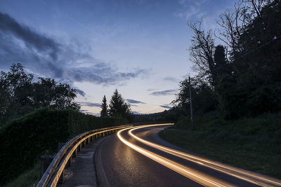 Road amidst trees against sky