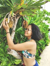 Portrait of young woman holding plant