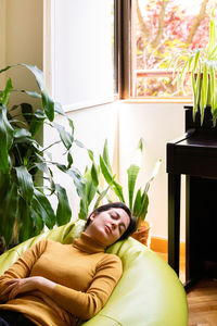 Woman relaxing on beanbag at home