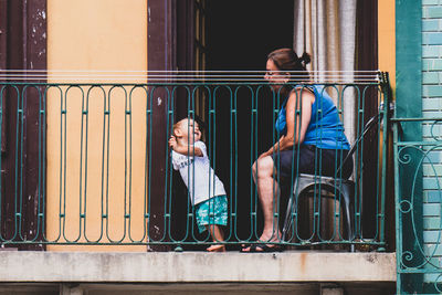 Men sitting on metal window