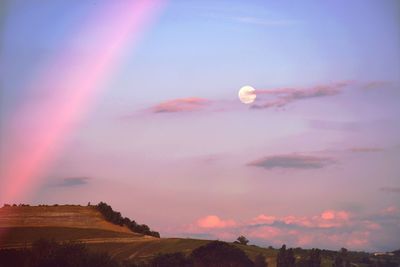 Low angle view of rainbow against sky at sunset